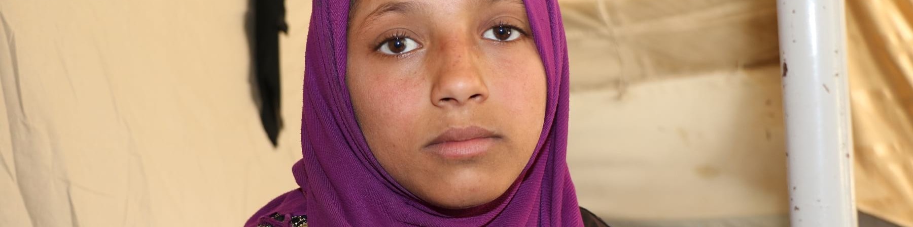 Primo piano di una bambina siriana con chador di colore viola