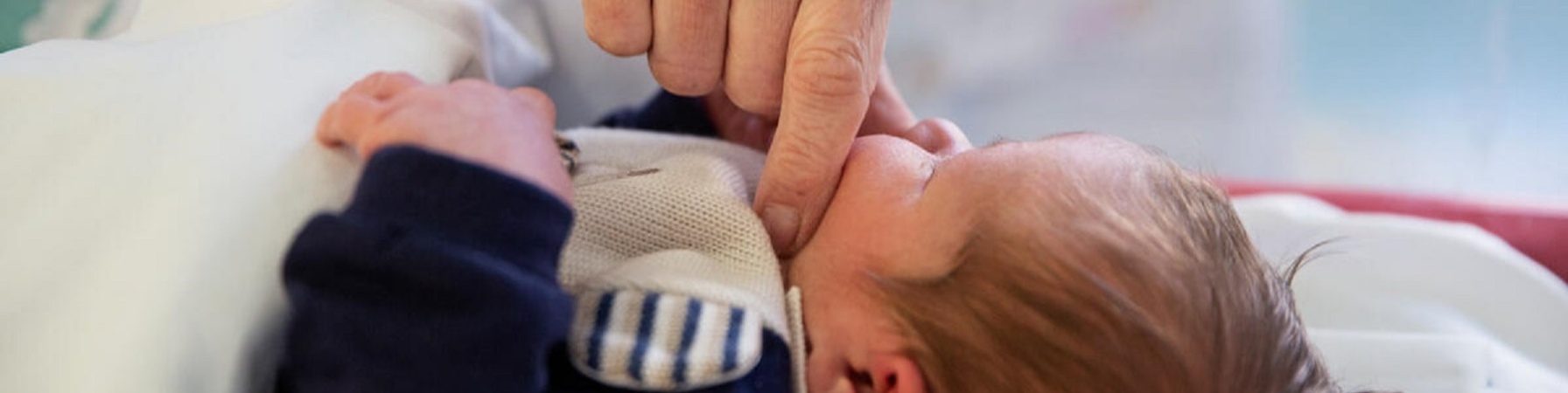 mano di un genitore a contatto skin to skin con neonato 