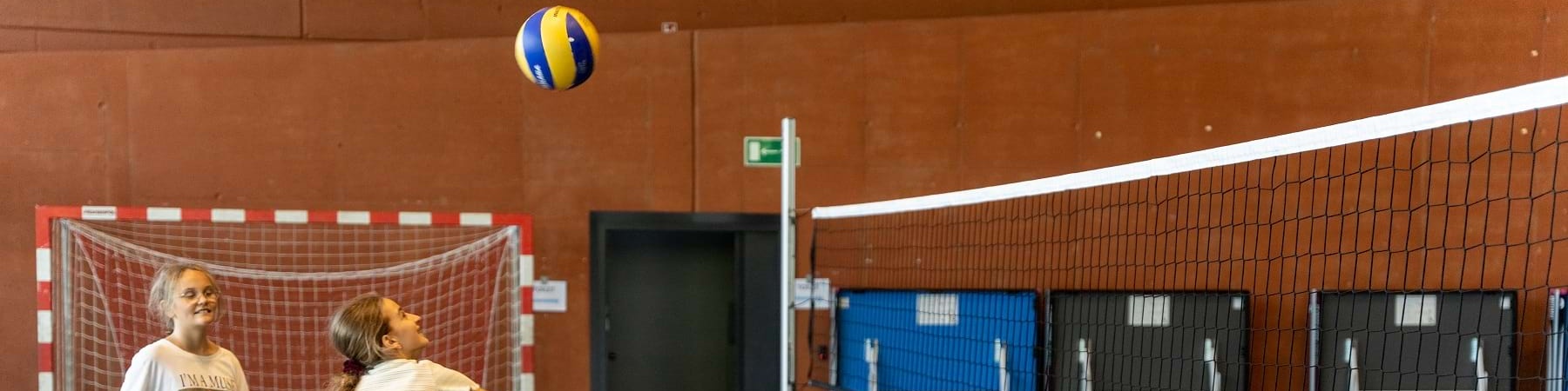 due bambine giocano in un campo di pallavolo