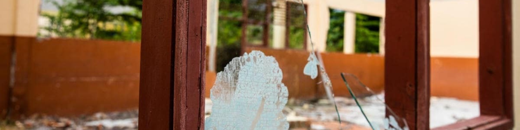 in primo piano il vetro rotto di una scuola distrutta dal terremoto in indonesia