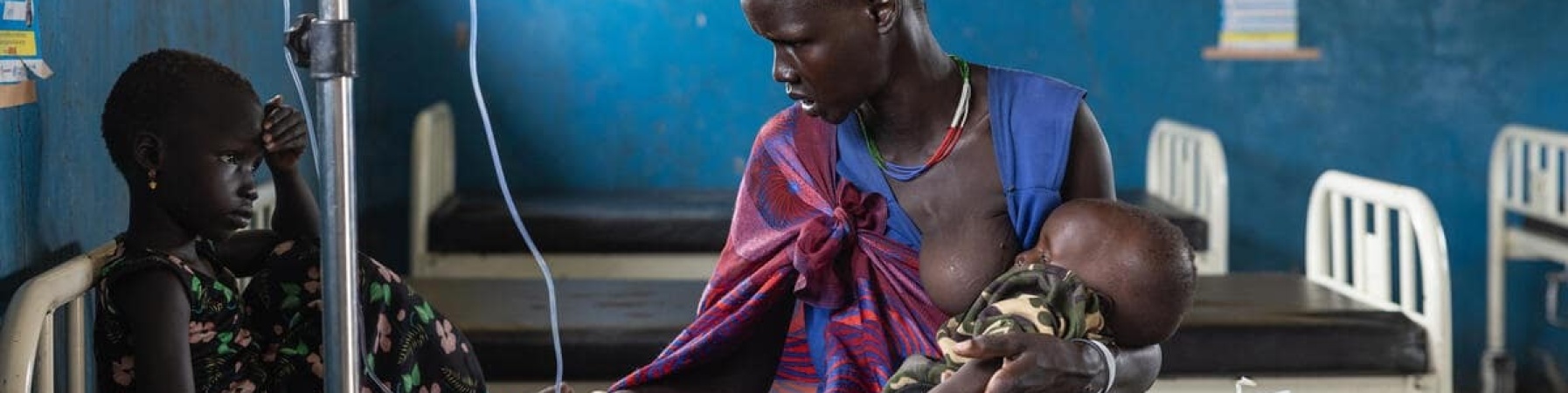 madre con in braccio il proprio bambino affetto da malnutrizione acuta grave e accanto a lei altro figlio sul letto di ospedale