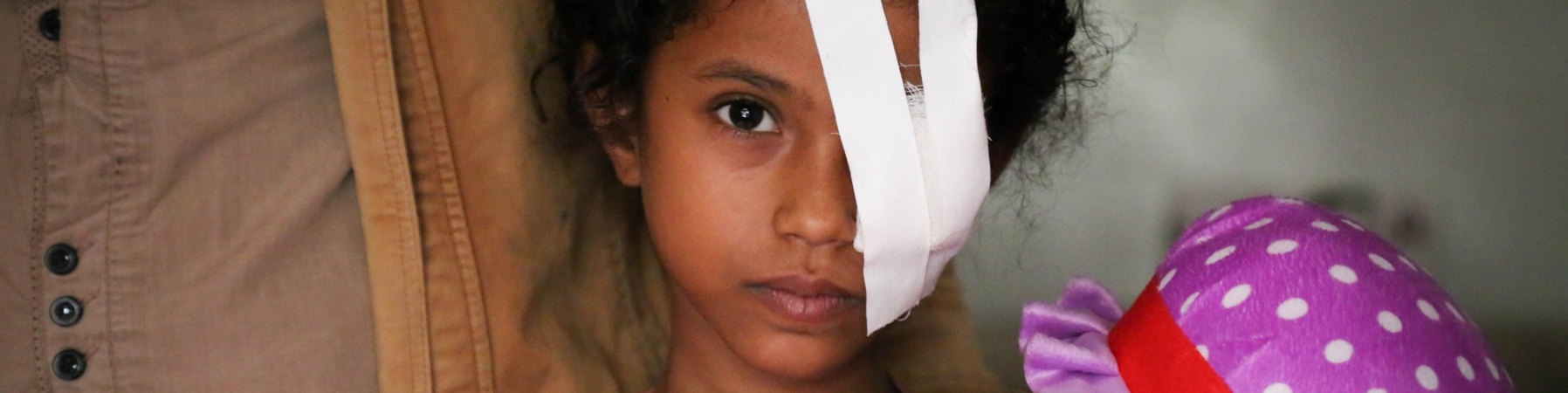 Bambina con benda su un occhio insieme al padre Yemen