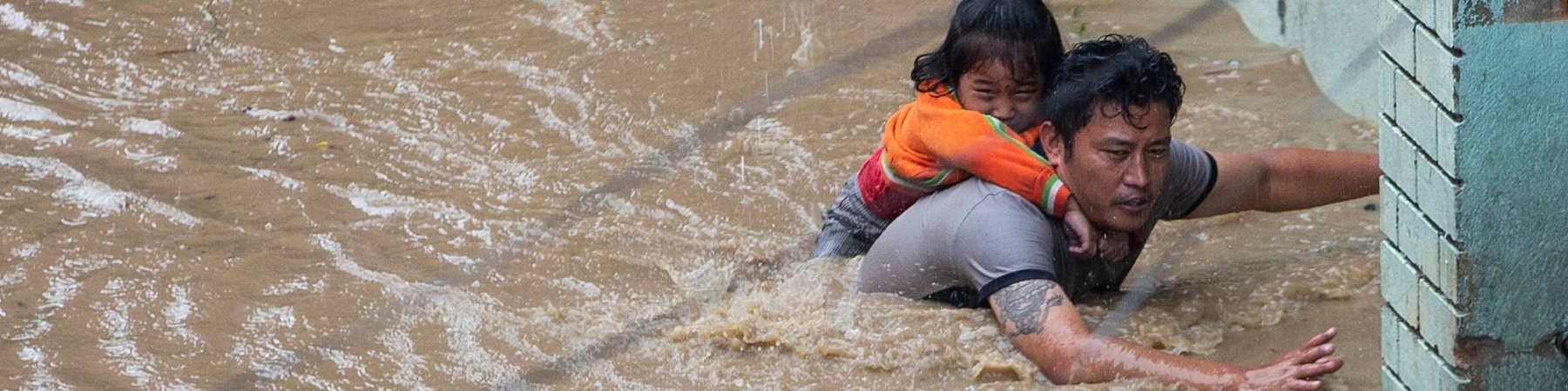 Un padre con la sua bambina che cerca di mettersi in salvo dall acqua alta