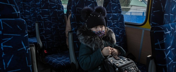 In questa foto una bimba ucraina è seduta sul bus di Save the Children per essere portata in Italia.