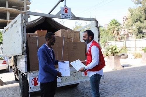 La consegna degli aiuti. Un operatore di Save the Children consegna gli aiuti a un partner locale