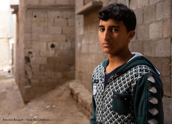 ragazzo palestinese con felpa grigia guarda verso di noi con sguardo triste