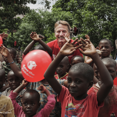 Cesare Bocci insieme ad altri bambini che ridono durante la visita sul campo nel nostro progetto in Africa nel 2018