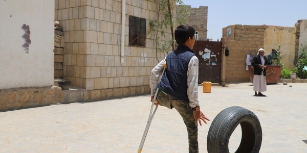 bambino senza una gamba in Yemen in piedi con una stampella 