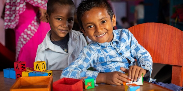 due bambini nepalesi giocano insieme seduti a un tavolo