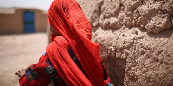 Bambina afghana di spalle con foulard rosso