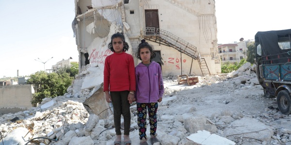 Due bambine siriane in piedi tra le macerie