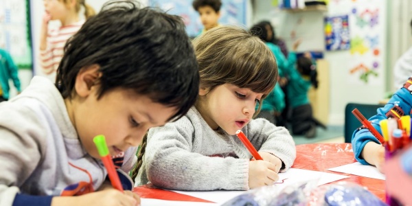 due bambini di 5 anni disegnano con matite seduti a tavolino