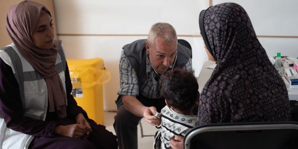medico a gaza che offre assistenza sanitaria a bambina e donne
