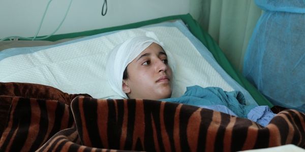 Adolescente yemenita in letto di ospedale con fasciatura alla testa