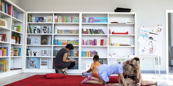 bambini e bambine nella biblioteca di uno dei punti luce di save the children italia