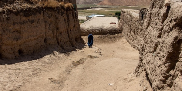 ragazza con velo cammina tra le mura della città iraniana