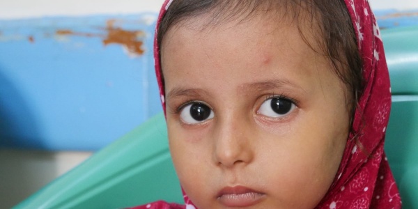 Primo piano bambina yemenita con velo rosso