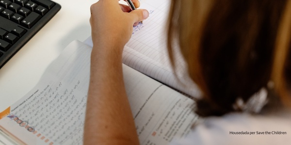 dettaglio di braccio e mano che scrivono su un quaderno di scuola