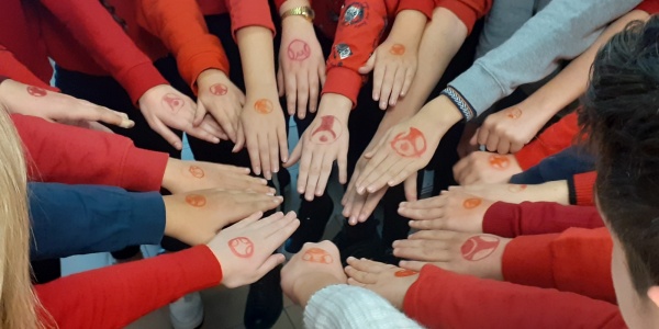 mani di ragazzi che si uniscono e sulle loro mani il logo di save the children