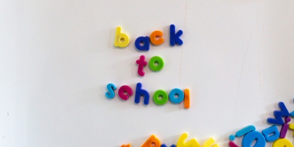 lavagnetta magnetica con lettere colorate unite a formare la scritta "Back to school"