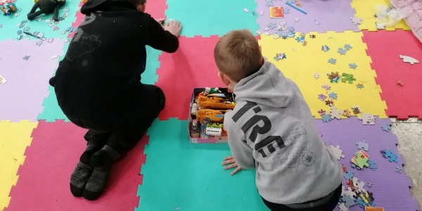 due bambini che giocano su un tappetino colorato pieno di giochi