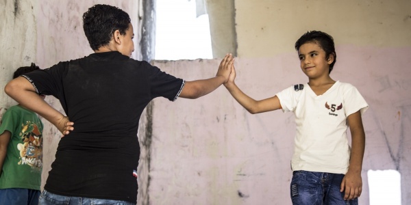 due ragazzi in piedi si danno il cinque con la mano