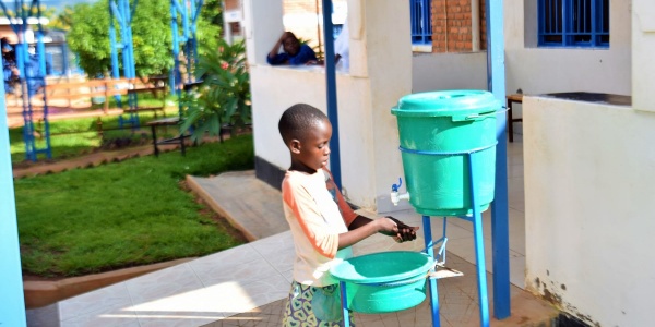 bambina del Rwanda lava le mani con rubinetto portatile