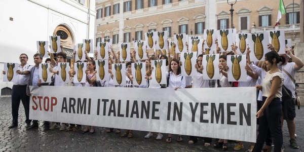 Gruppo di persone davanti a Monte Citorio tengono uno striscione con la scritta "Stop armi italiane in Yemen"
