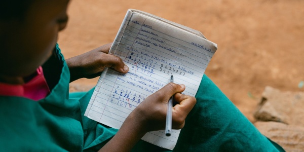 bambina che calcola su un quaderno 