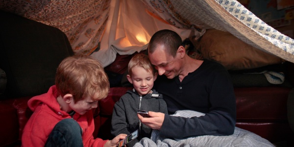 Papà con i propri figli in una tenda che giocano