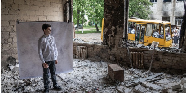 guerra in Ucraina ragazzo in stanza distrutta dai bombardamenti che guarda fuori 