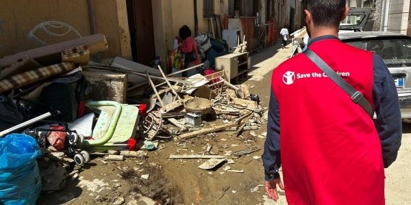 Operatore Save the Children dall'alluvione in Emilia Romagna cammina vicino a casa con fango