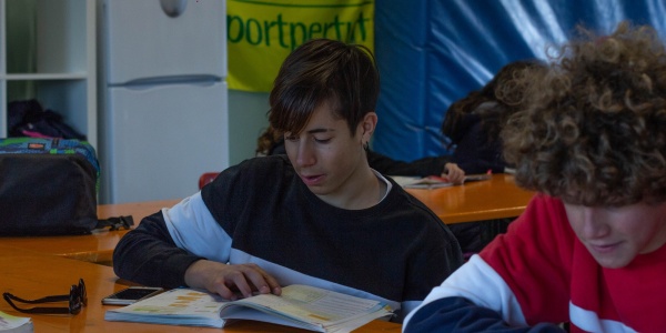 due ragazzi seduti a un banco in un aula di un punto luce stanno facendo i compiti di scuola