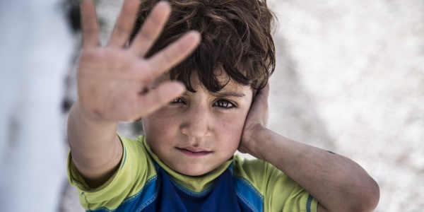 primo piano bambino libanese con mano in primo piano aperta davanti al volto