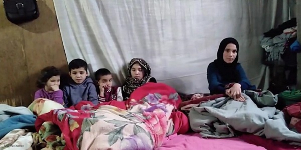 Famiglia libanese che si scalda sotto a una coperta