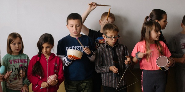 bambini e bambine che fanno musica a scuola con strumenti musicali in mano 