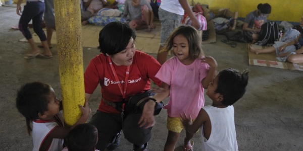 Operatrice save the children parla con bambini in spazio a misura di bambino allestito nelle Filippine per emergenza eruzioni vulcano Taal