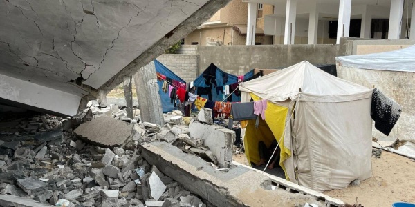 tenda con famiglia accampata tra le macerie a Rafah