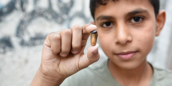 bambino palestinese nella Striscia di Gaza con un proiettile in mano 