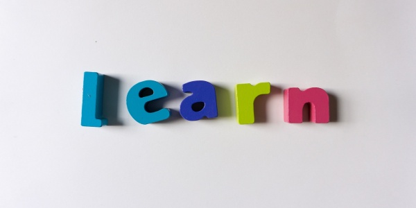 lavagnetta magnetica con attaccate lettere colorate a formare la parola learn