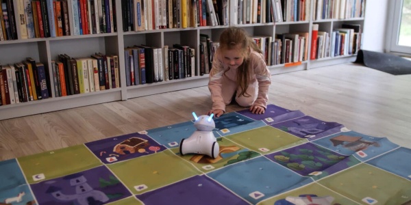 gioco stem per bambina che gioca con robot su un tappeto 