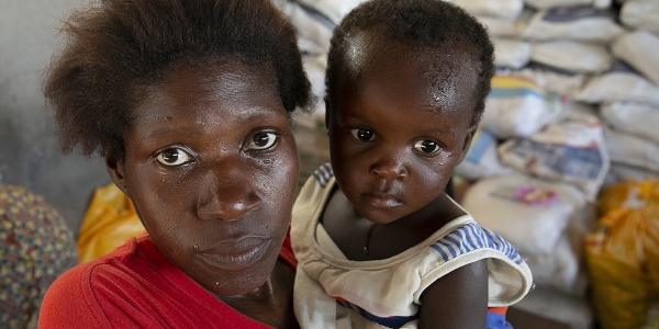 Primo piano di mamma e figlio di origine mozambicana. Il bambino è in braccio alla donna.