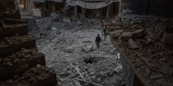 foto dall alto di un quartiere in Siria bombardato, nel sentro un uomo che cammina