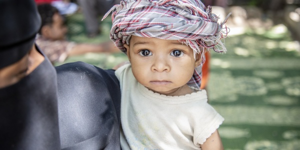 Guerra in Yemen bambino dello yemen con kefiah in testa in braccio alla mamma