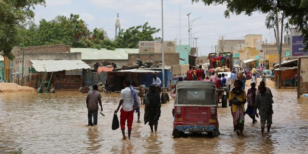 Popolazione somala sfollata a causa delle alluvioni cammina in acqua fangosa