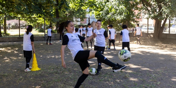bambine che giocano a calcio ed in primo piano una di loro calcia la palla