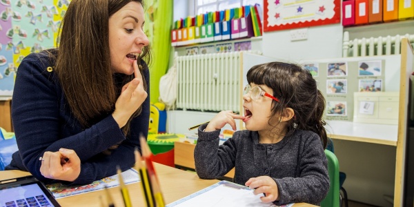 mamma e bambina giocano insieme sedute a un piccolo banco 