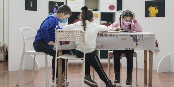 Tre bambini studiano a un tavolino