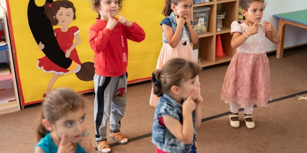 5 bambine giocano in piedi all'interno di un asilo nel campo di zaatari in Giordania