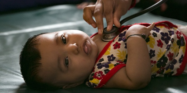 Bambina neonata Rohingya viene visitata stesa con stetoscopio.